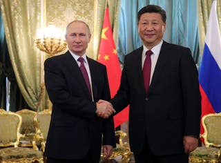 Vladimir Putin shakes hands with Chinese leader Xi Jinping during their meeting in Moscow
